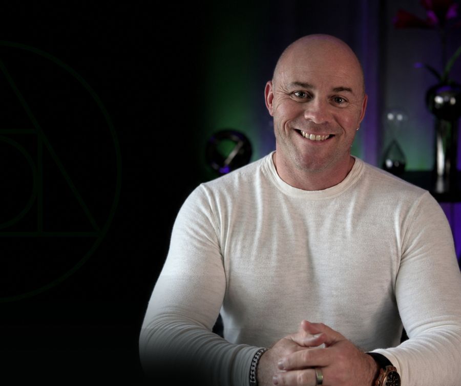 Adam Cox, clinical hypnotherapist, smiling in his studio